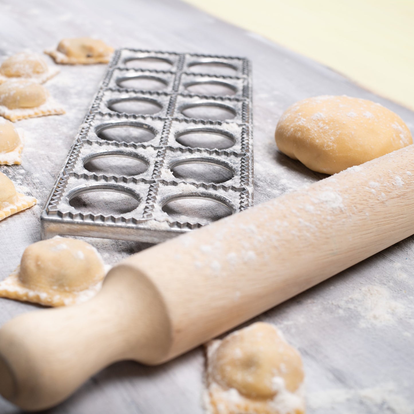 Ravioli making process with a rolling pin and on a floured surface