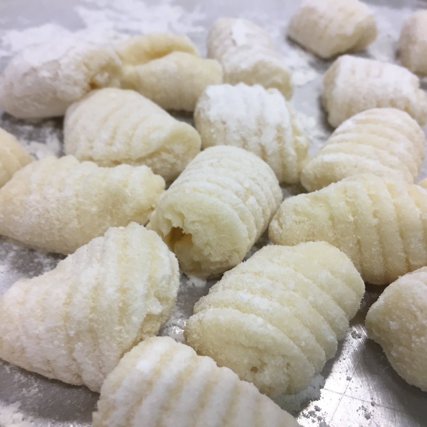 Raw gnocchi on a floured surface. Learn how to make gnocchi perfectly evertime with this cooking class.